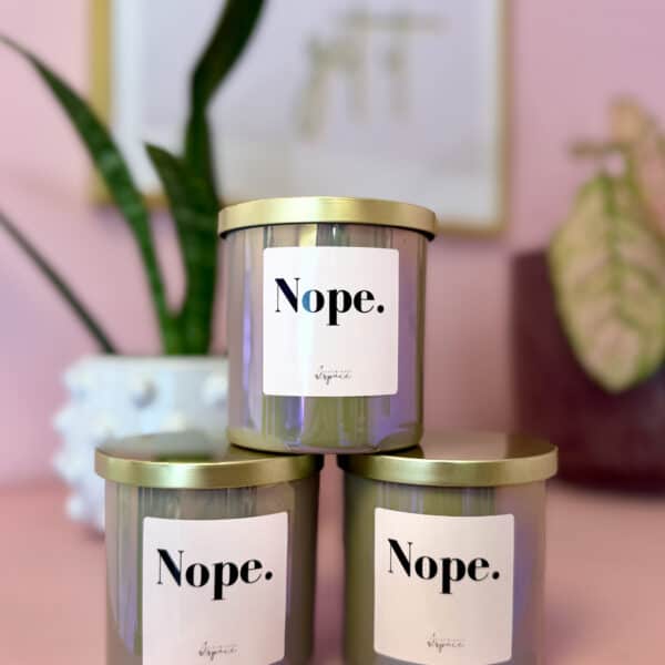 Hand-poured taupe iridescent soy candle with a “nope” label and gold lid, available in a variety of seasonal scents