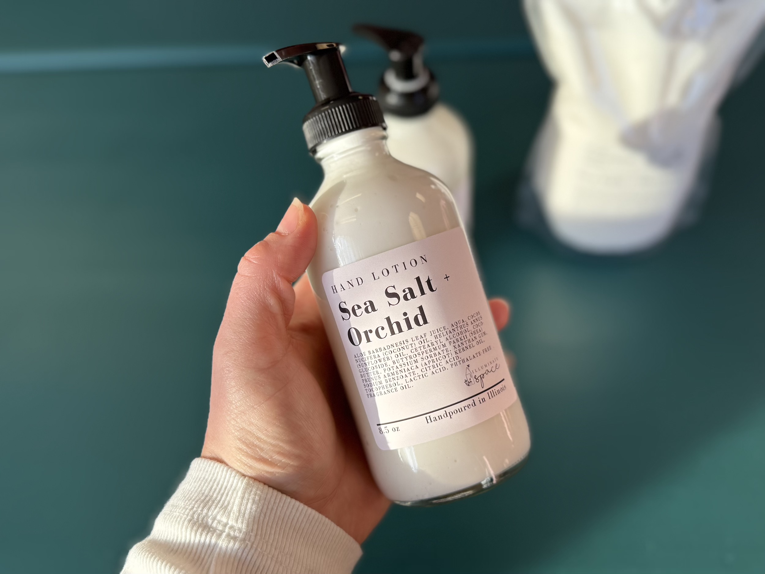 Illuminate Space hand lotion in an 8.5oz glass bottle with a pump dispenser.